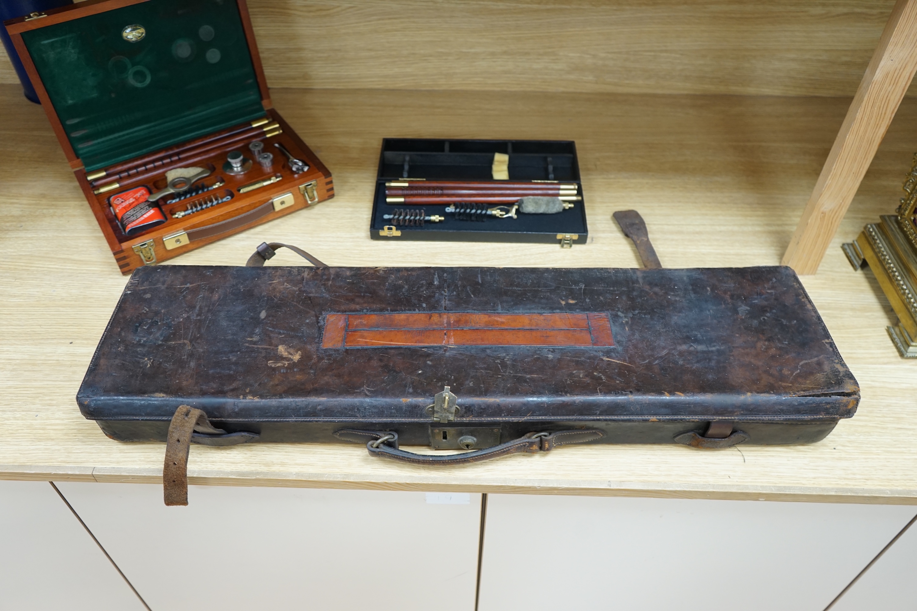 Two cases of gun cleaning equipment and a 19th century leather gun case, 83cm long. Condition - fair to good